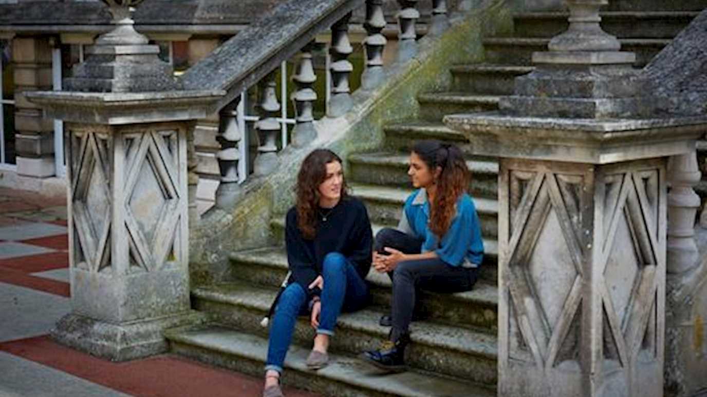 Students sat on founder steps - Fees and funding (Santander International Excellence)