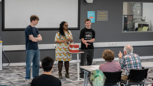 Diverse group of students presenting design concept to judging panel