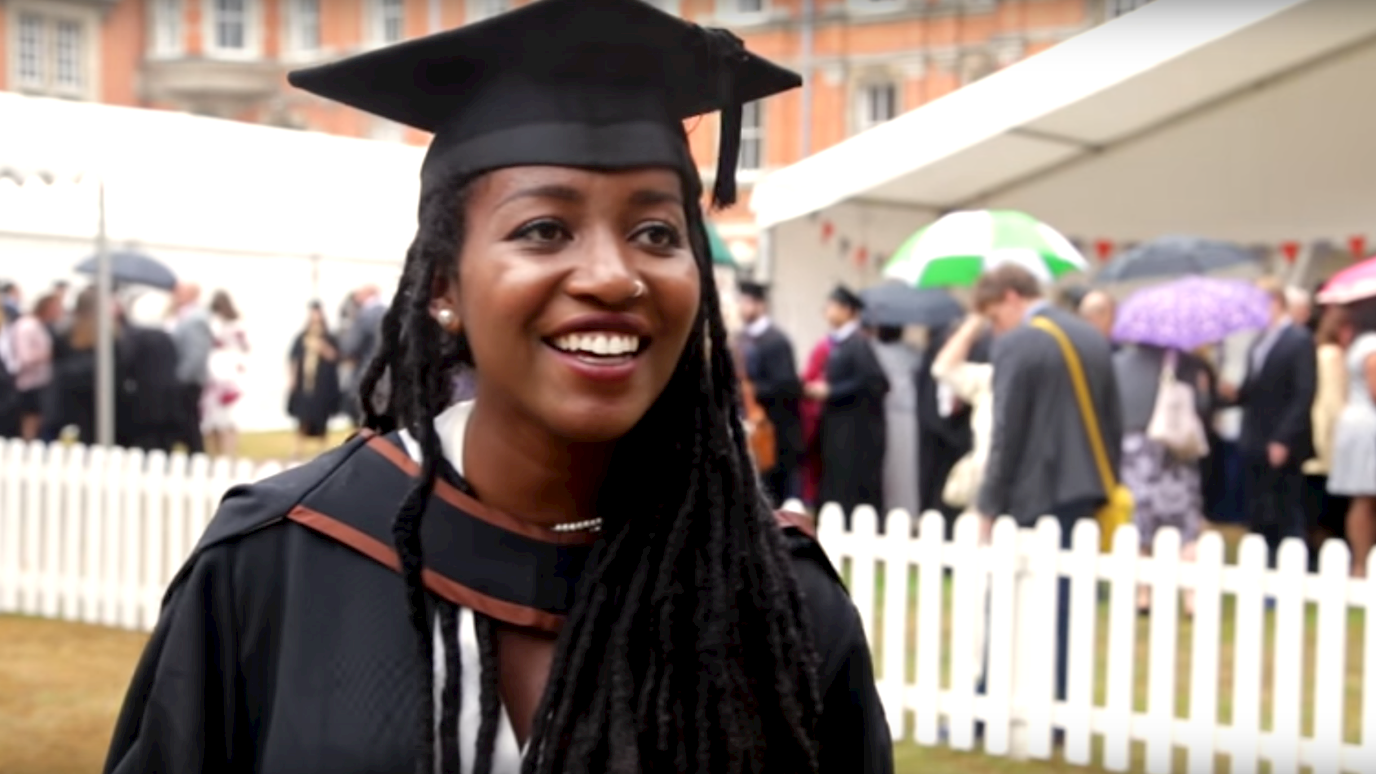 History graduate in gown at summer graduation - History