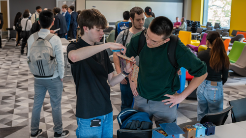 Student demonstrating electronic prototype at showcase event