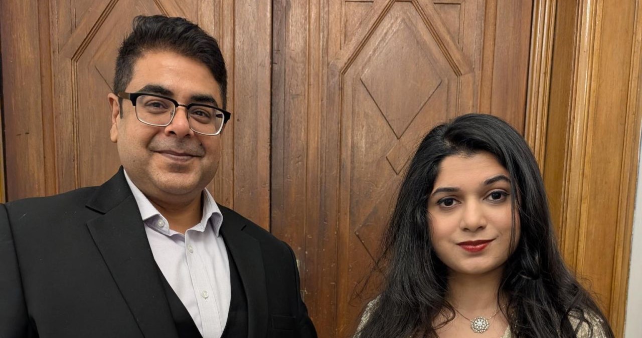 one male one female alumni selected as India Achievers 2026 standing in front of a wooden door