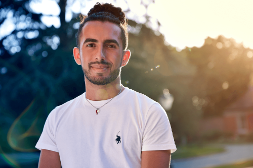Man standing outside, with sun behind